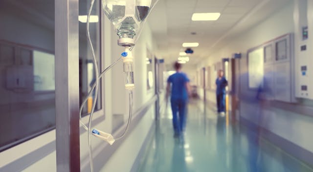 blurred image of clinicians walking down a hospital hallway
