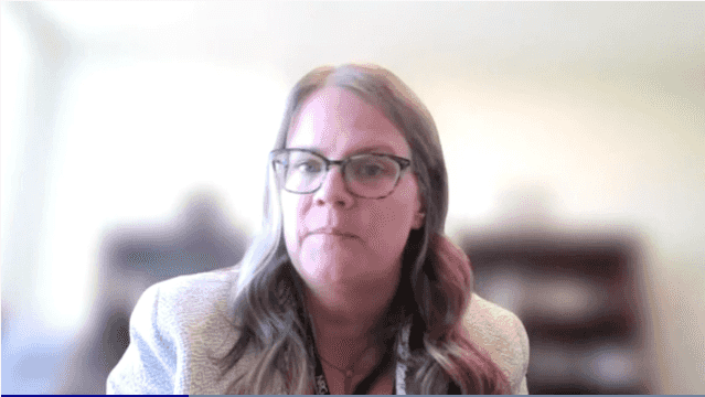 Image of a woman with wavy blonde hair wearing glasses.