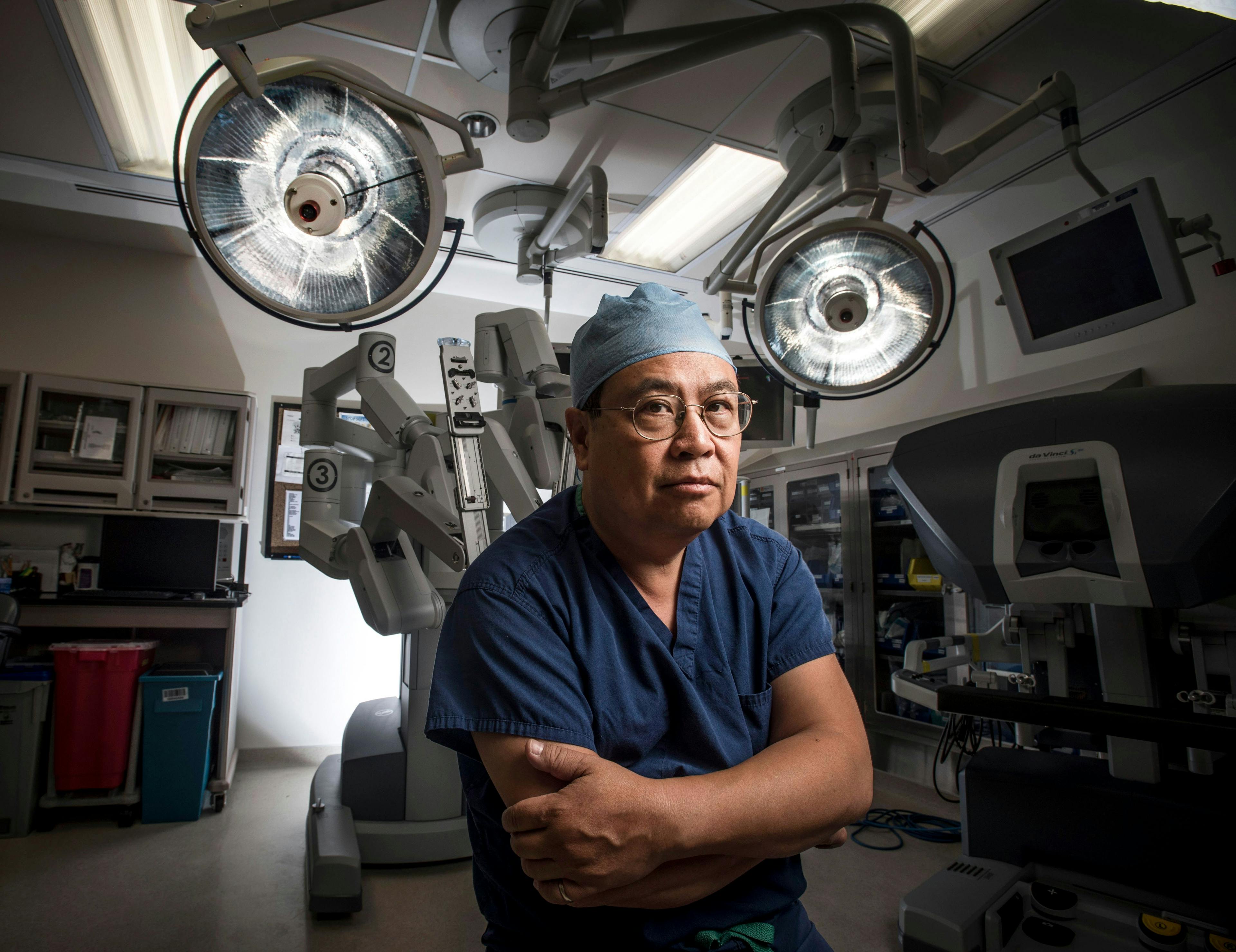 Photo of Dr. Yuman Fong in front of robotic surgical instruments
