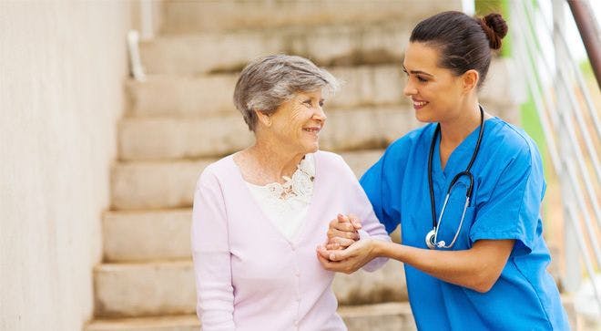 Image of a medical professional helping a patient down the stairs. 