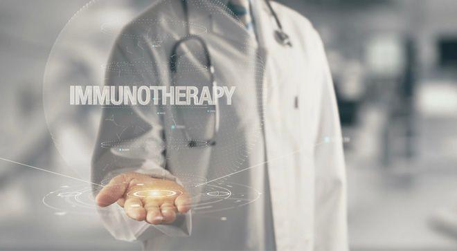 Image of a doctor's hand with the words "immunotherapy" over their hand. 