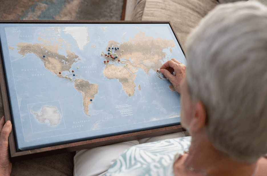 Image of a woman looking at a large map with pins in different areas.