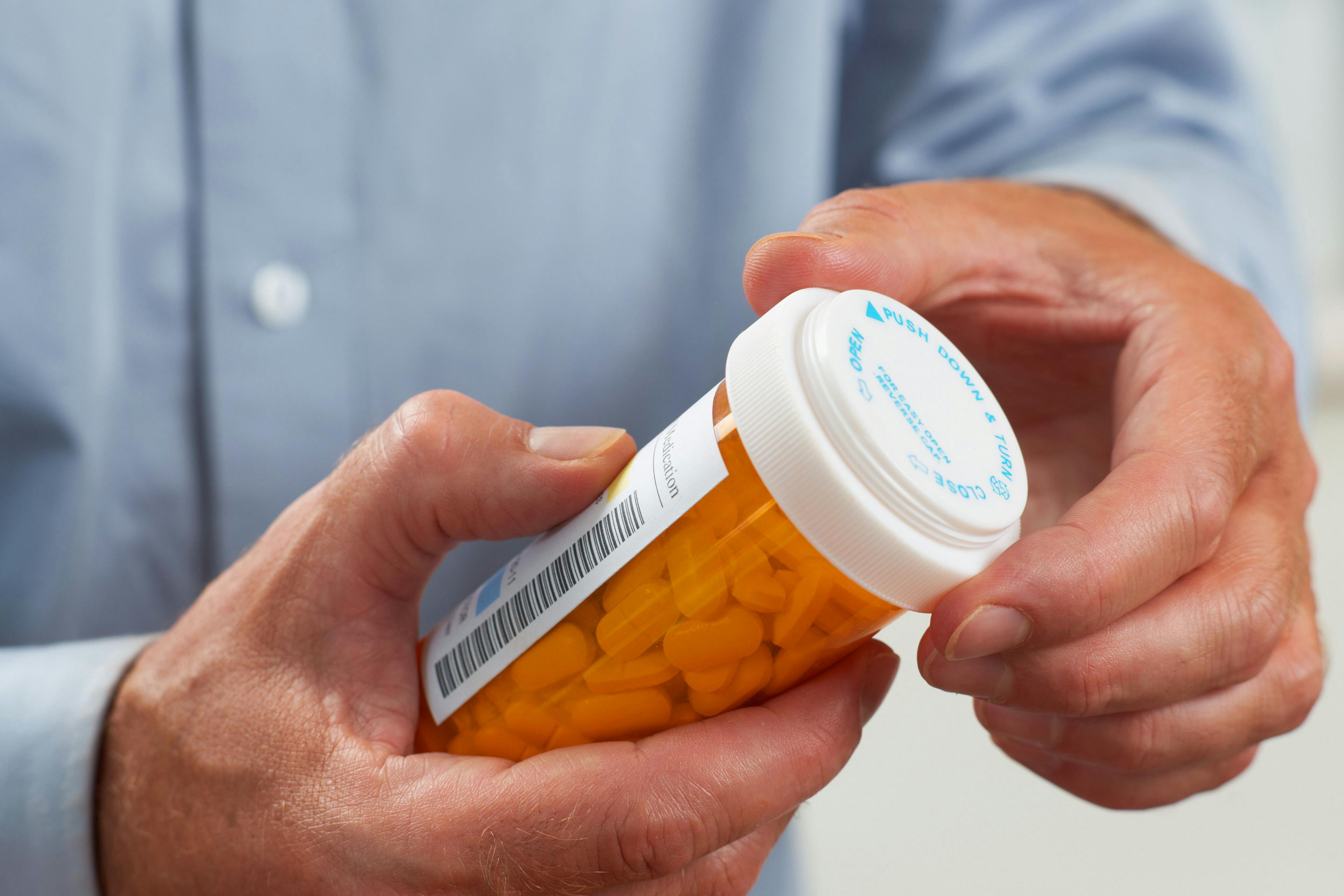 Image of a patient holding a prescribed bottle of pills.