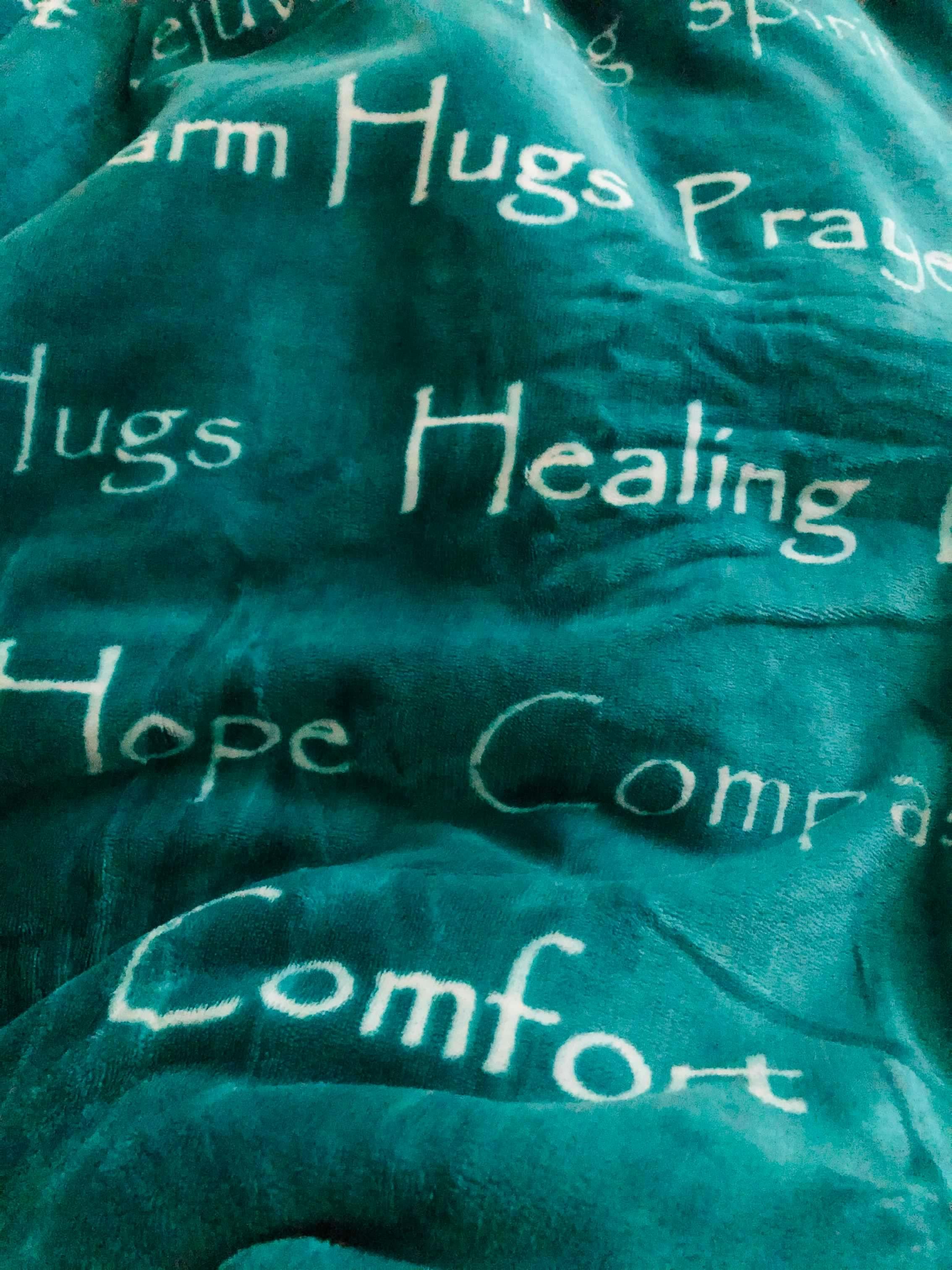 Image of a teal blanket with words of encouragement on it. | Photo credit: Jezebel Corpuz