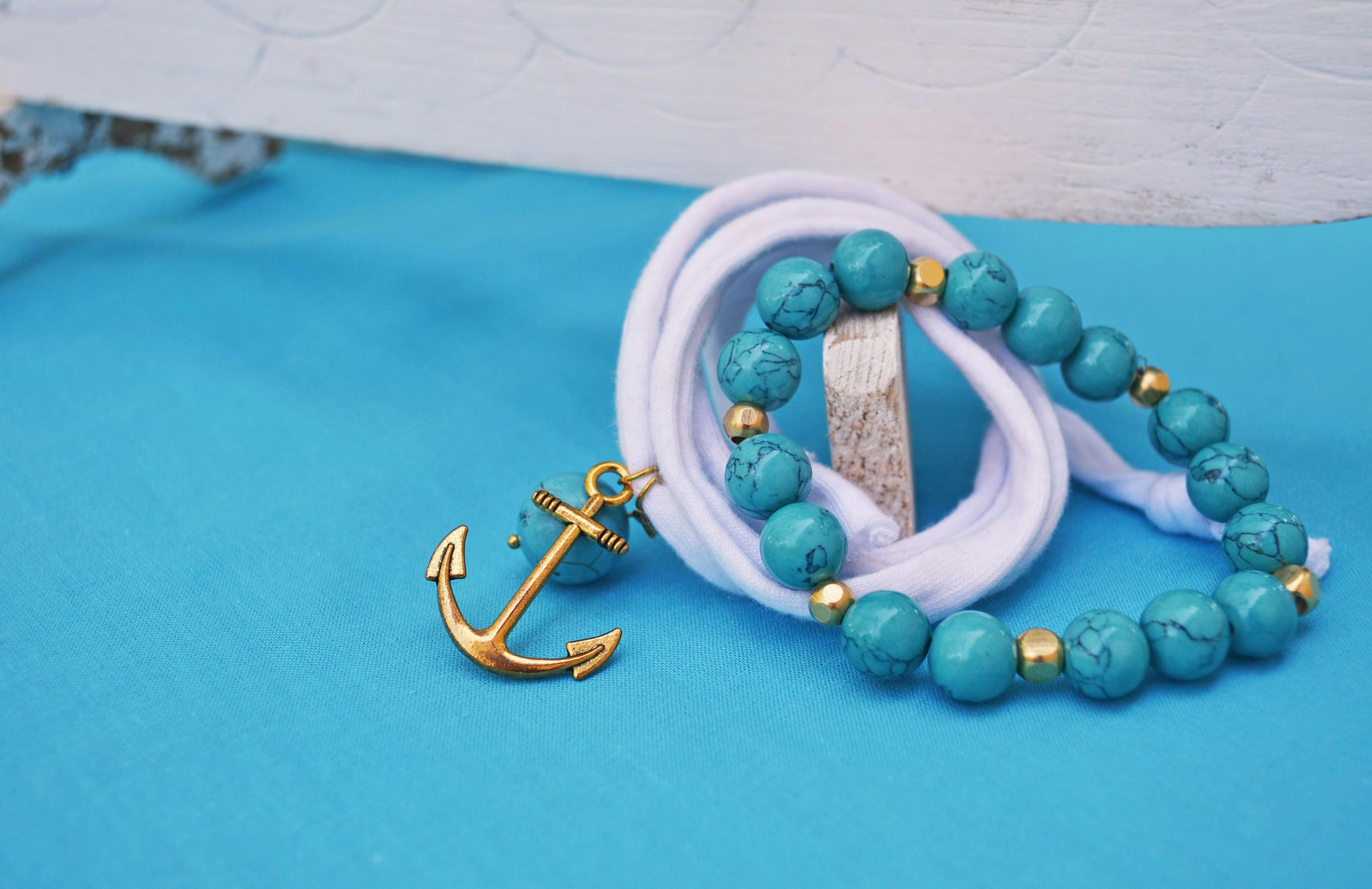 summer jewelry - turquoise gemstone bracelet and gold anchor charm | Image credit: © photo_stella - stock.adobe.com