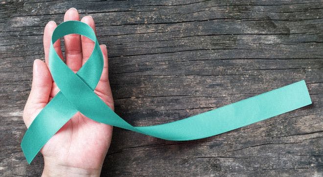 Image of a person holding an ovarian cancer ribbon.