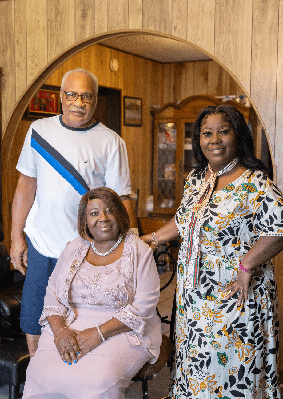 Image of a family of three, posing for a picture in their living room.