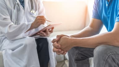 Image of a doctor talking with a male patient. 