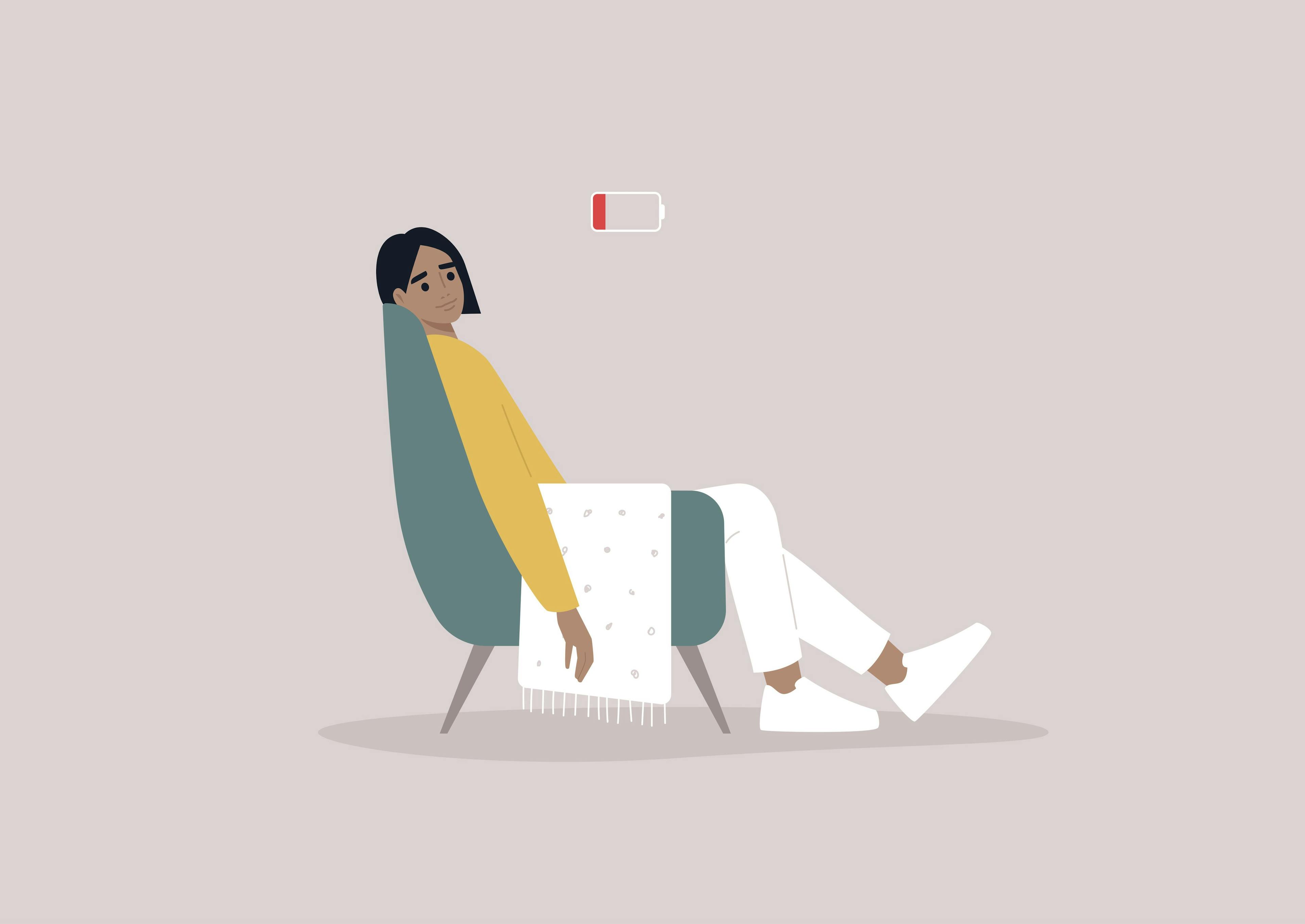 A young female exhausted character sitting in a chair with a low battery indicator above | Image credit: © - nadia_snopek © - stock.adobe.com